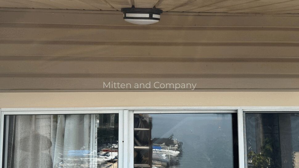 Soffit and sliding door on multifamily unit | Mitten & Company Soffit and exterior light above sliding glass door with marina reflection