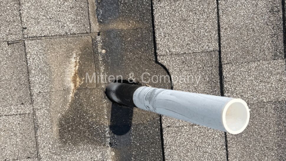 Roof vent pipe with dark staining around the boot on asphalt shingles