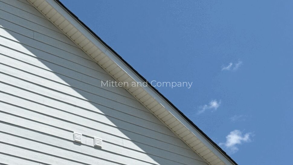 Close-up of white horizontal siding, soffit, and roofline on a home.