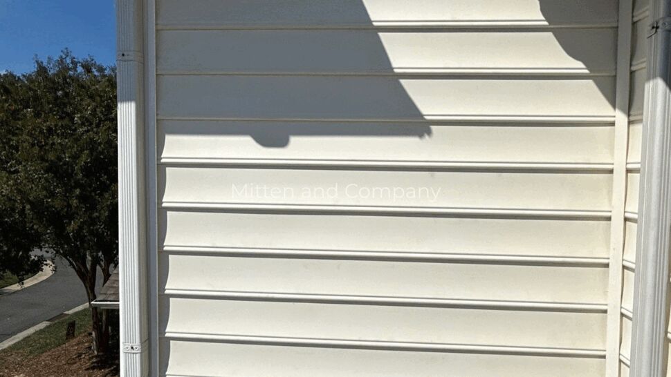 White Siding Over Stone Foundation | Mitten & Company White siding above a stone foundation with a white downspout