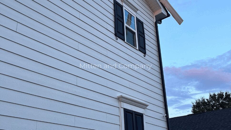 White horizontal siding and black-shuttered windows on a two-story home.