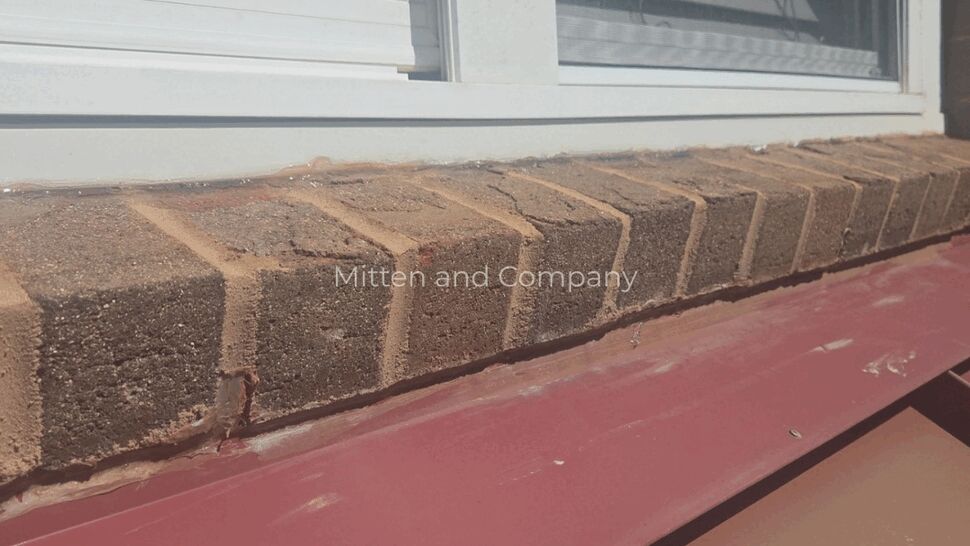 Window Roof Flashing Detail | Mitten & Company Roof flashing beneath a white window on a brick building