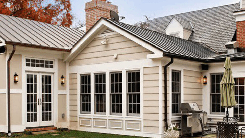 Backyard view of a home with a metal roof, chimney and patio area