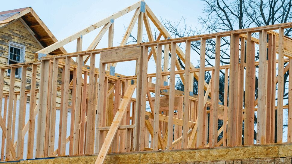 Exterior wood framing and roof trusses rising above a new residential structure.