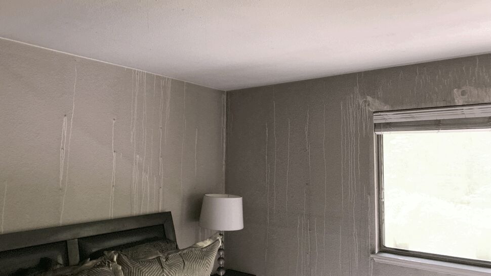 Bedroom walls and ceiling streaked with soot and smoke residue.