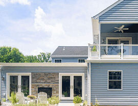 Blue house with a rear addition, stone fireplace and patio seating