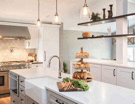 White farmhouse kitchen with apron sink and hanging pendant lights