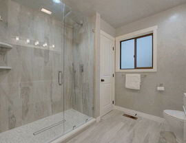 Spacious bathroom with glass walk-in shower and gray marble tile