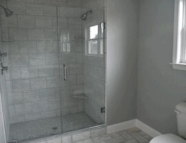 Frameless glass shower with marble subway tile and built-in seat