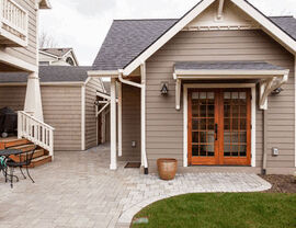House exterior with fresh siding, roof, and paved walkway.