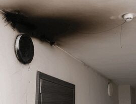 Soot-stained hallway ceiling around a vent and smoke detector.