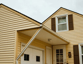 Yellow house exterior with vinyl siding and a small covered entryway
