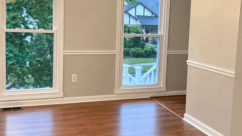 Formal Room Hardwood Flooring | TSP Contracting Formal room with polished hardwood flooring, crown molding, windows, and a crystal chandelier