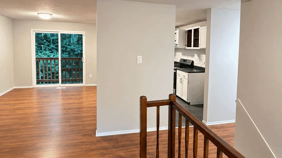 Open Living Area with Hardwood Floors | TSP Contracting Open living area with warm hardwood floors and a wooden stair railing
