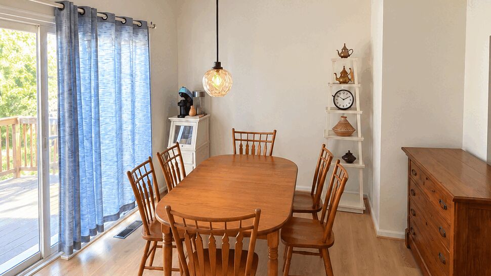 Dining area with wooden table on light waterproof vinyl flooring and pendant light
