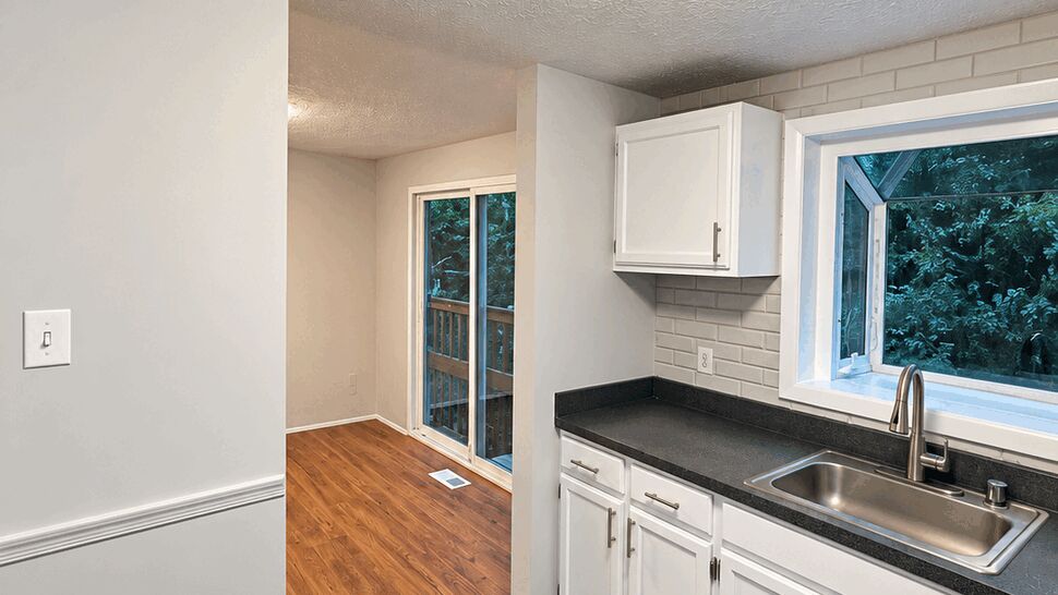 Bright Kitchen Renovation | TSP Contracting Updated kitchen with white cabinets, dark countertops, and stainless steel sink