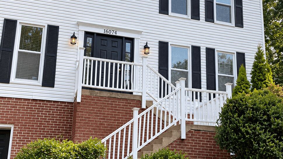 White Siding Home Exterior | TSP Contracting Two-story home with white siding, black shutters, brick foundation, and landscaped entry