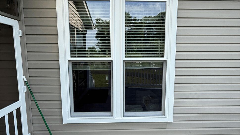 Pair of windows above a deck next to a screen door