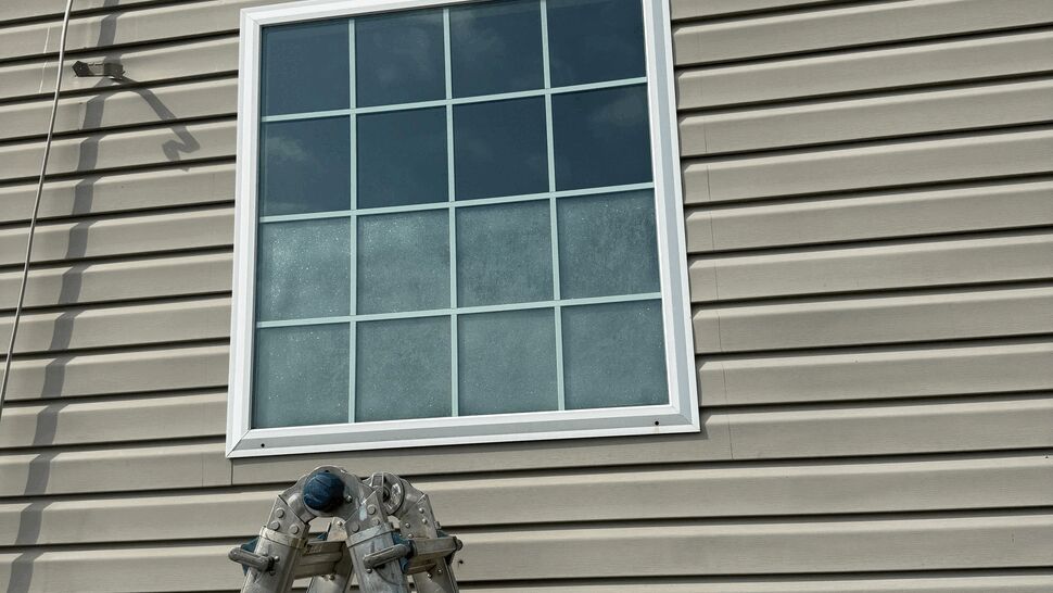 Square window with grid pattern and ladder below