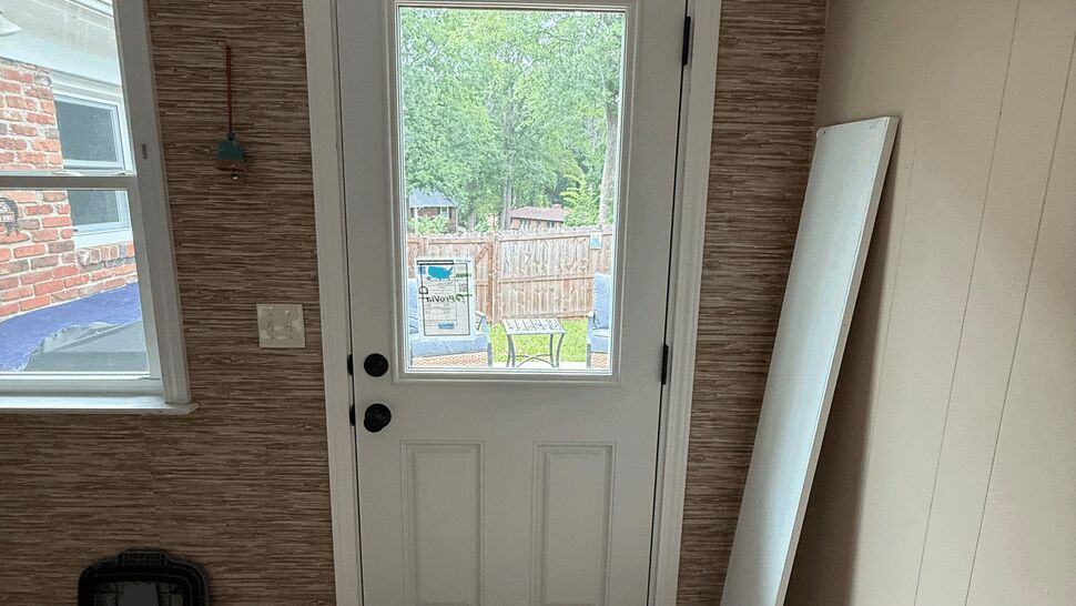 Interior white door with large clear glass panel and decorative shelf above