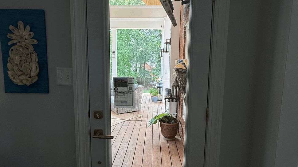 Interior view through a single glass exterior door to a covered porch