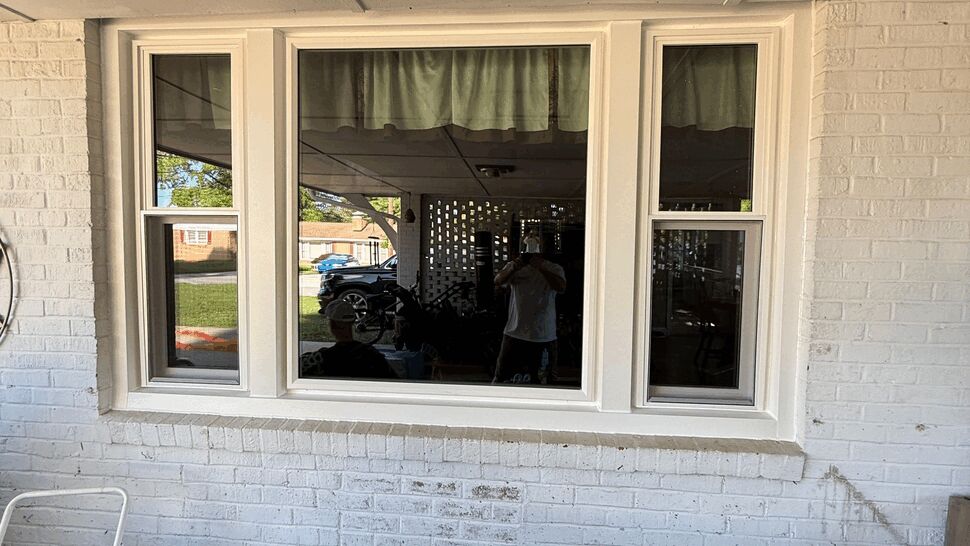 Large center picture window with narrow operable side windows under a covered porch