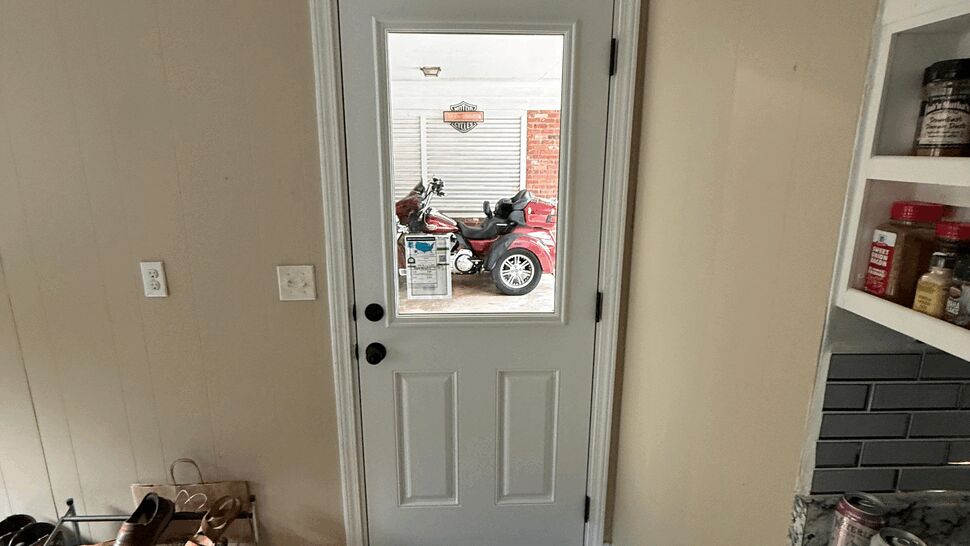 Narrow white kitchen entry door with clear glass panel looking into garage