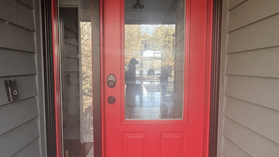 Red front entry door with a tall glass sidelight and keypad lock