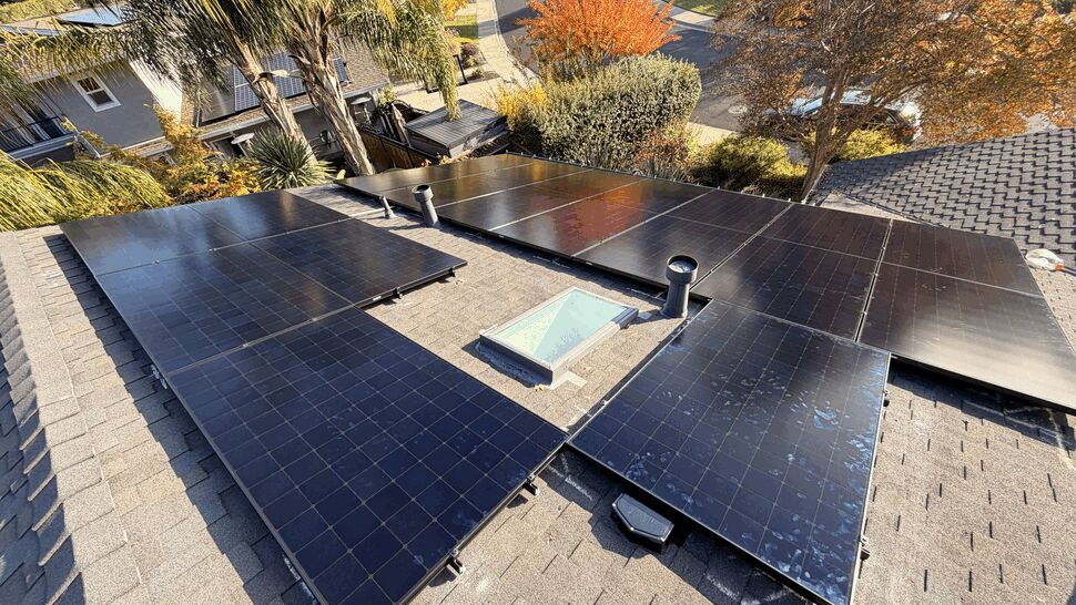 Top-down view of solar panels arranged around a skylight and roof vents on a home.