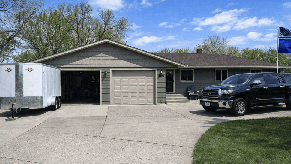 Front driveway view showing single garage, roofline and parked truck