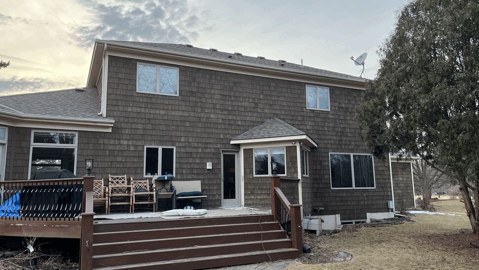 Rear Wooden Deck on Brown Sided Home | Lutgen Companies Rear brown house with wooden deck and stairs