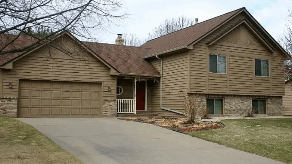 Split-Level Home Roofing and Siding | Lutgen Companies Split-level brown home with brick foundation, updated siding and asphalt shingle roof.