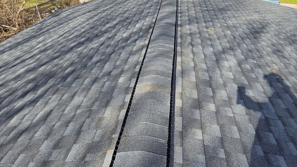 Completed gray asphalt shingle roof viewed from above.