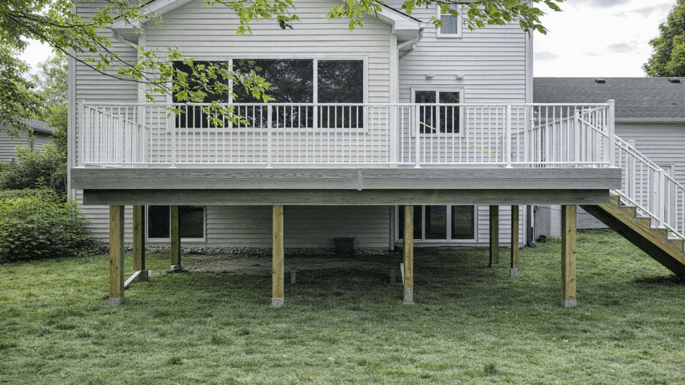 Wide backyard deck with gray decking and white railing