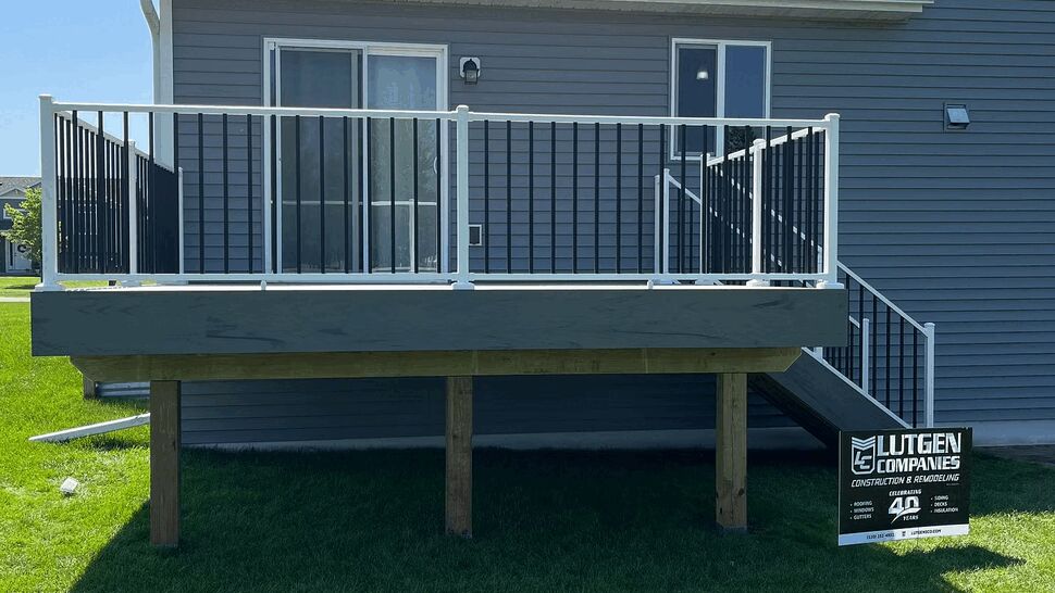 Elevated deck supported by wooden posts with Lutgen Companies sign