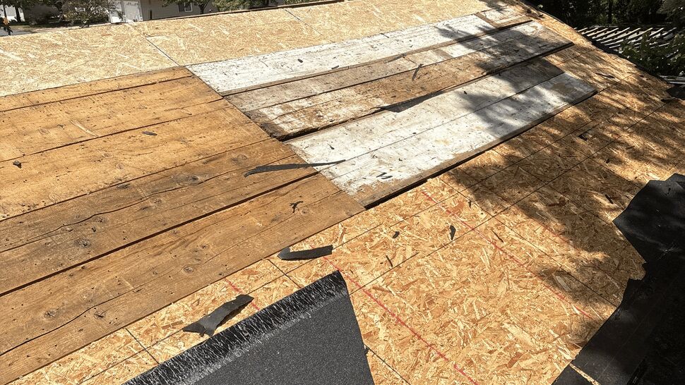 Roof with exposed plywood decking and black underlayment during a roofing project