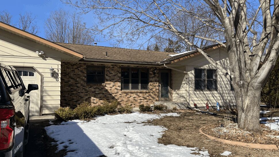 Front of home showing roofline above brick and siding facade