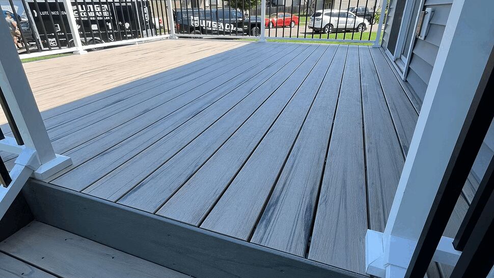 Close-up of gray composite deck boards and white railing