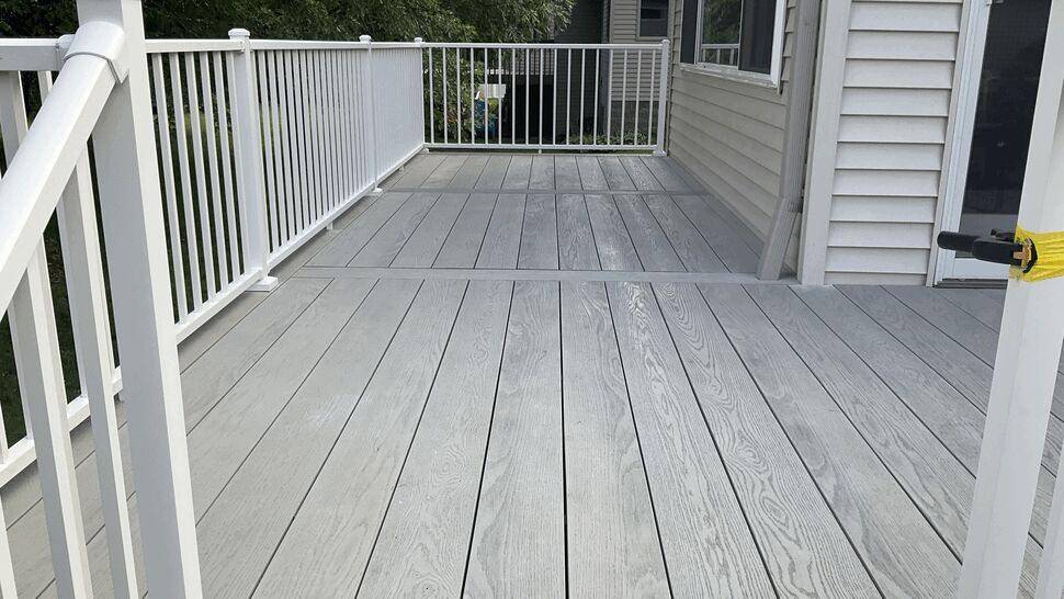Close view of gray composite deck boards and white railings