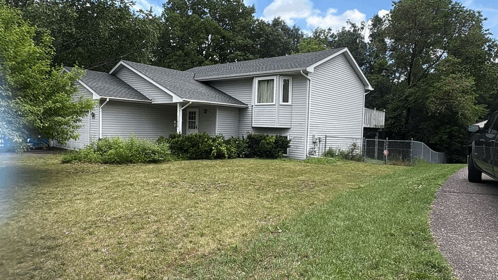 Front of home with siding and roof | Lutgen Companies Gray split-level home with a new GAF Timberline UHDZ shingle roof and attached garage after replacement by Lutgen Companies