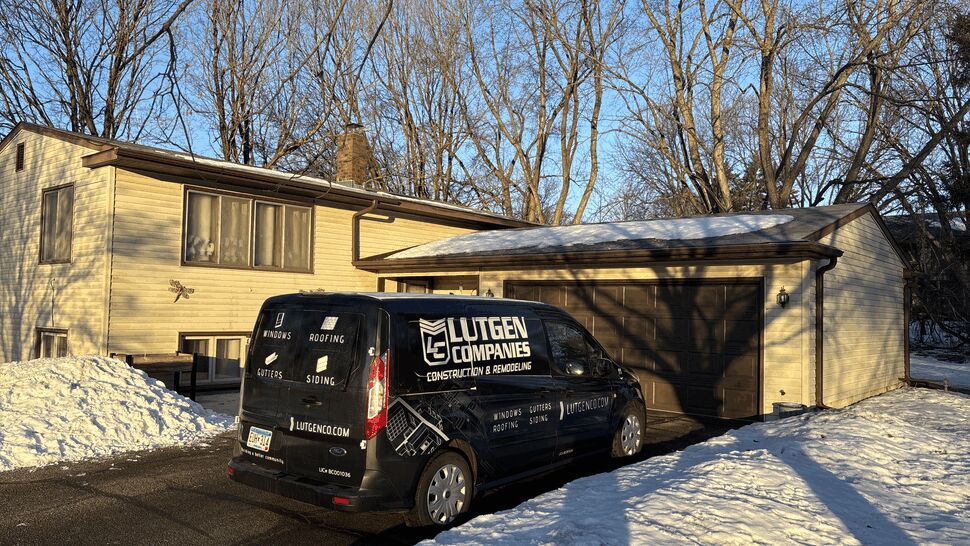 Lutgen Companies service van parked beside a home in winter.
