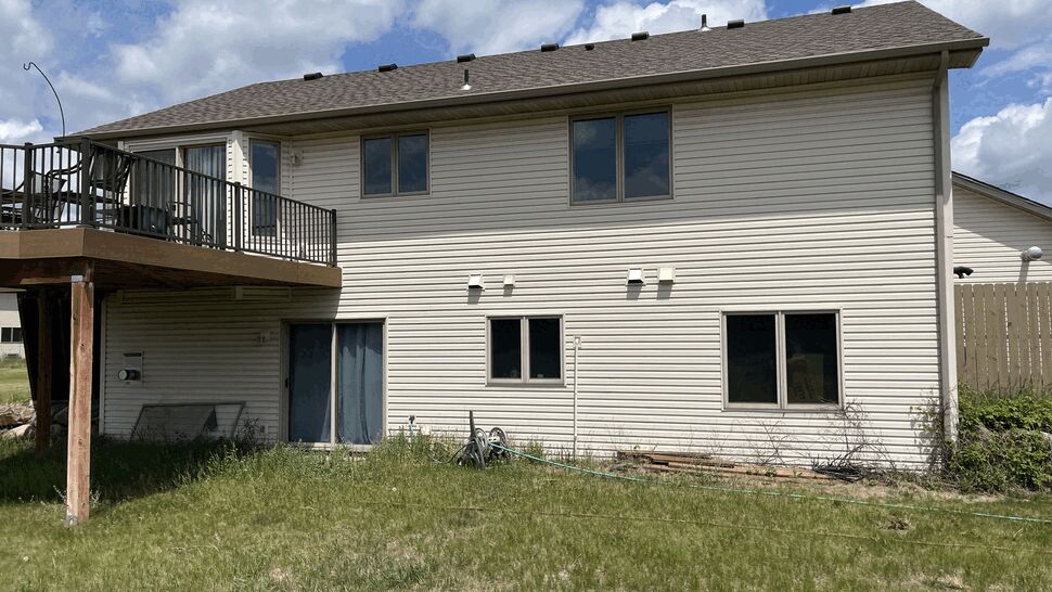 Raised backyard deck and siding | Lutgen Companies Original windows on the rear elevation of a two-story home in Big Lake, MN before replacement