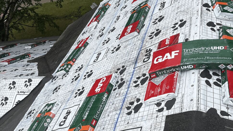 Bundles of GAF Timberline UHDZ shingles and Seal-A-Ridge staged on a roof covered in GAF TigerPaw underlayment