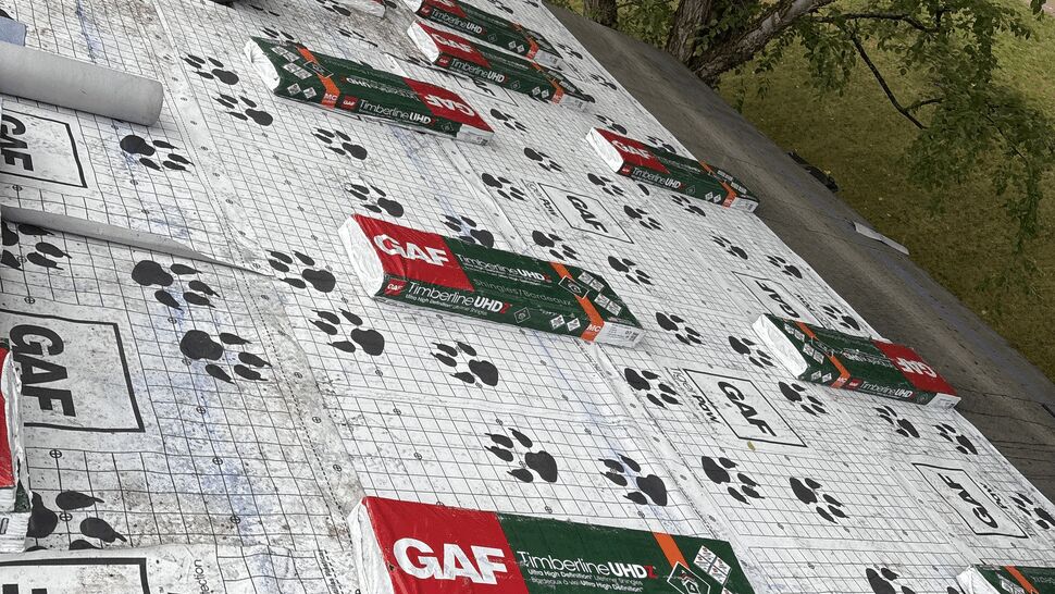 Roofing prep with GAF shingle packs | Lutgen Companies Bundles of GAF Timberline UHDZ shingles and Seal-A-Ridge staged on a roof covered in GAF TigerPaw underlayment