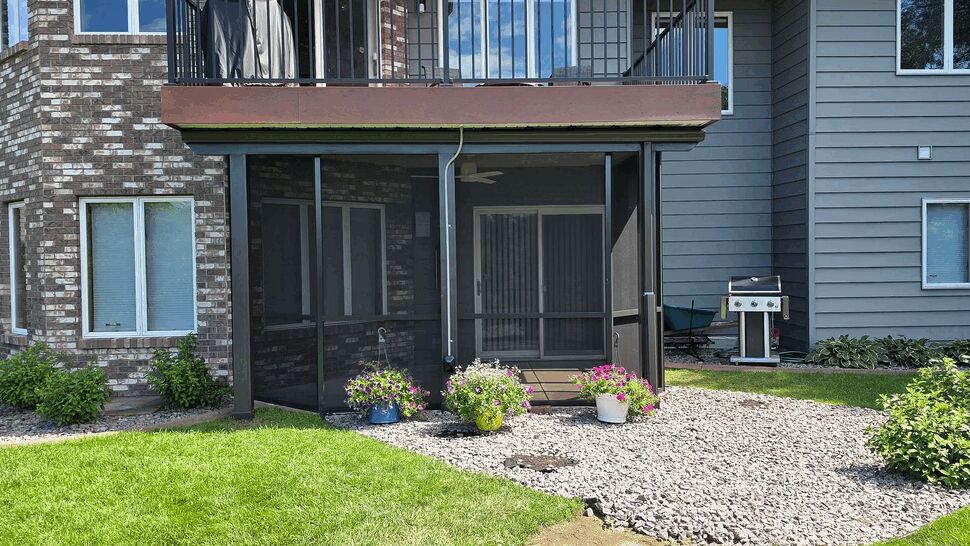 Screened lower deck with upper balcony and stone landscaping