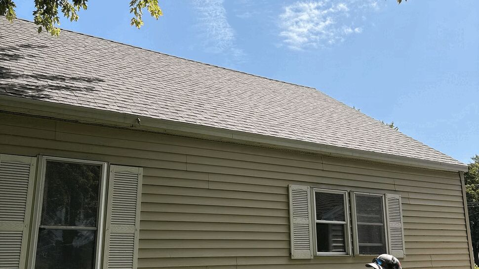Side elevation showing vinyl siding | Lutgen Companies Side of house with vinyl siding, windows, and a person wearing a Lutgen shirt.