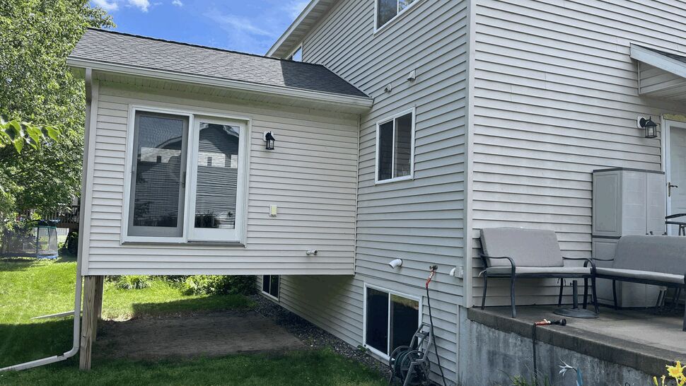 Home addition with light siding, windows, and a glass entry door