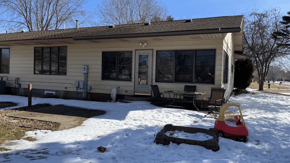 Rear patio with outdoor seating and child's toy in a snowy yard