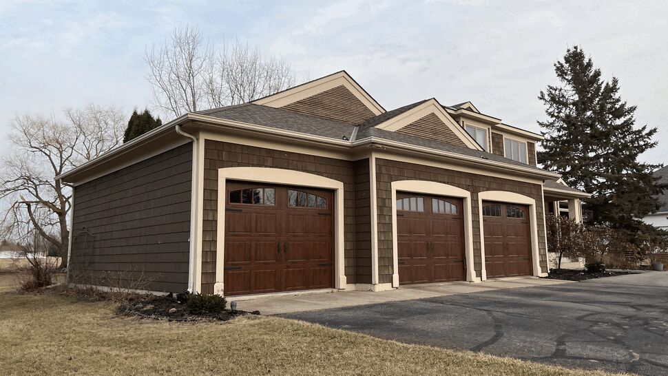 Three-Car Garage with Wood-Style Doors | Lutgen Companies Three-car garage with wood-style doors and brown siding