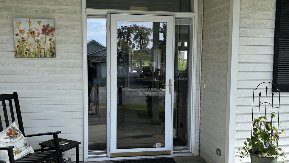 White glass storm door on porch | Lutgen Companies Exterior door replacement in St Cloud before picture